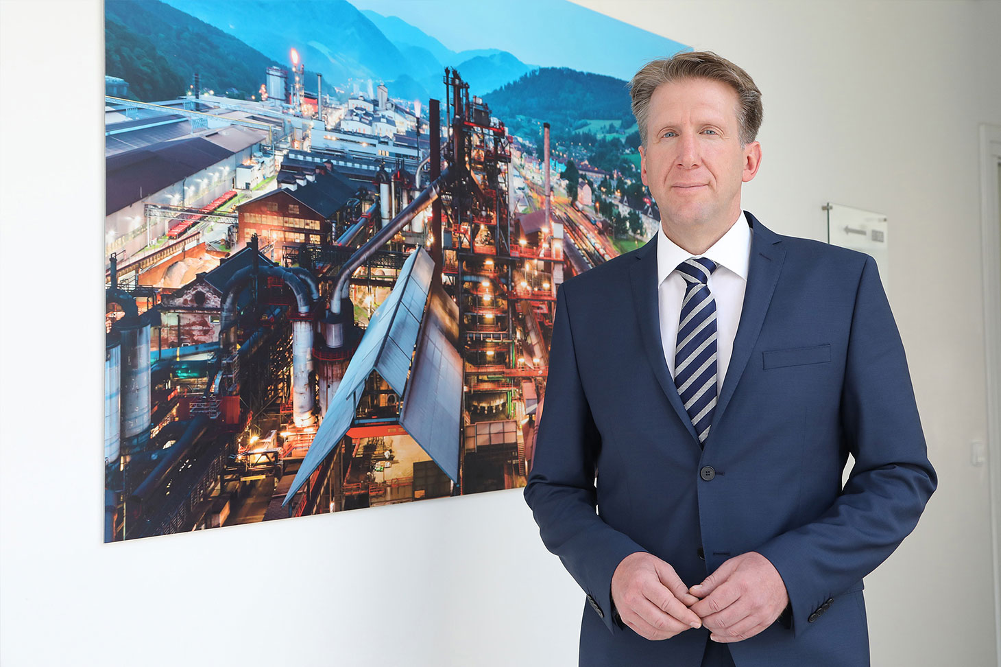 Gerhard Schuster, Technical Managing Director of voestalpine Stahl Donawitz GmbH, in front of a - still - current picture of Donawitz