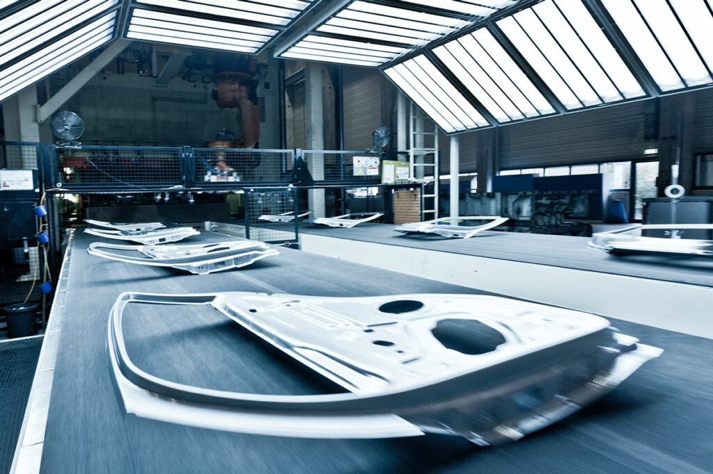 in a voestalpine Polynorm factory hall, car parts made of newly developed hot-dip galvanized body steel are transported on a conveyor belt