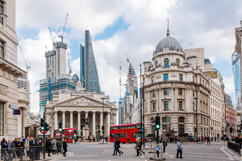 Financial District in London mit roten Doppeldeckerbussen und Passanten