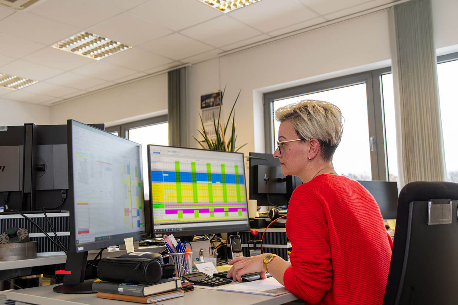 Fabienne sits at her desk with two screens in front of her