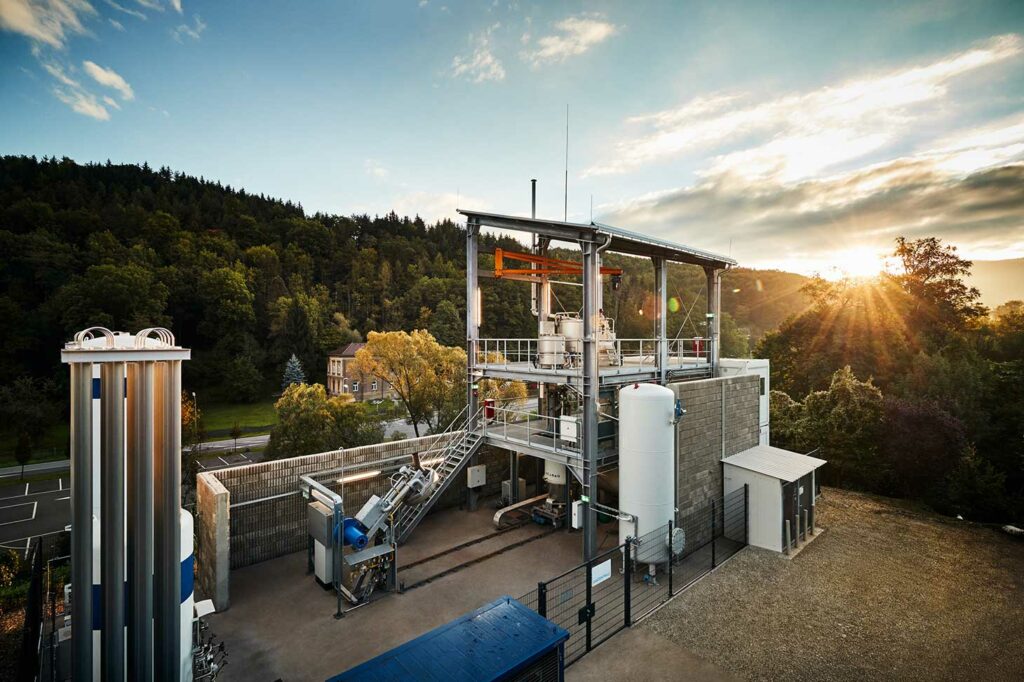 SuSteel Anlage der voestalpine mit Wasserstoff-Plasmatechnologie, im Hintergrund Wald