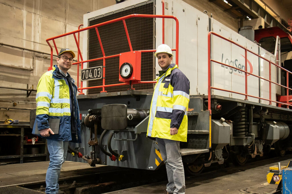 Benjamin in der Bahnwerkstätte mit Michael K. vor einer Logserv Verschublok.