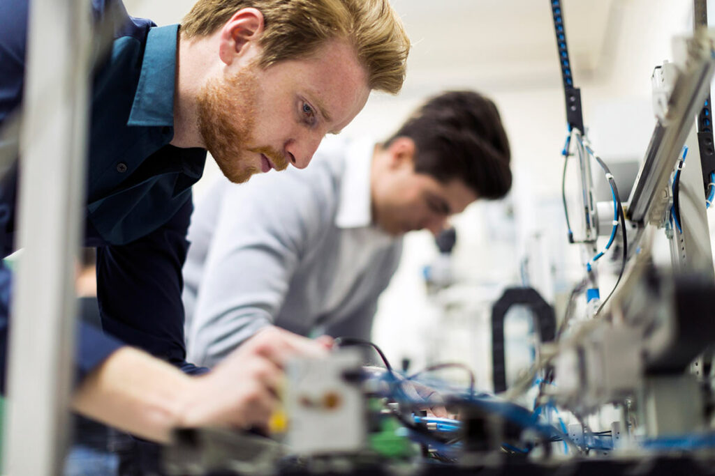 Two men working intently with electrical cables