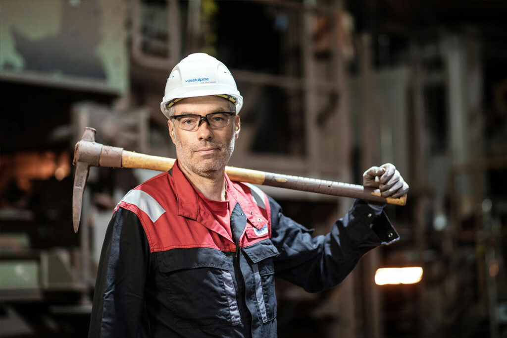 Portrait voestalpine Johannes mit seinem Werkzeug über seiner Schulter gelegt