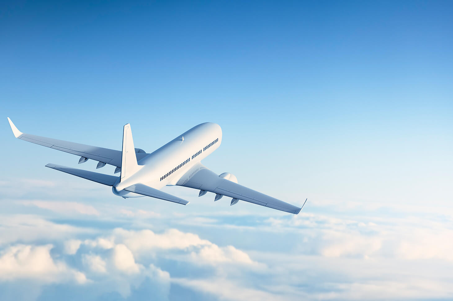 Airplane from behind flies above the clouds