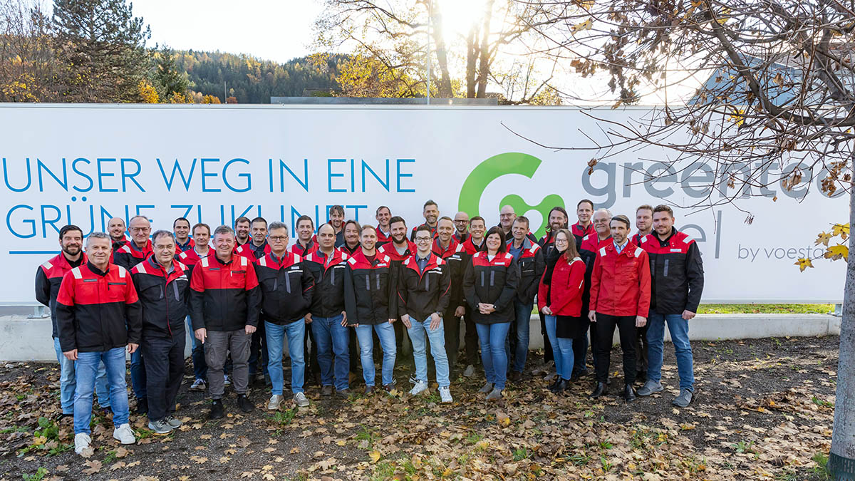 Gruppenfoto greentec steelvor dem Transparent unser Weg in eine grüne Zukunft