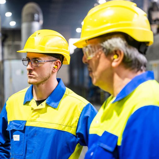 Lothar und Enkel Sebastian mit Schutzkleidung in einer Werkshalle von BÖHLER Aerospace