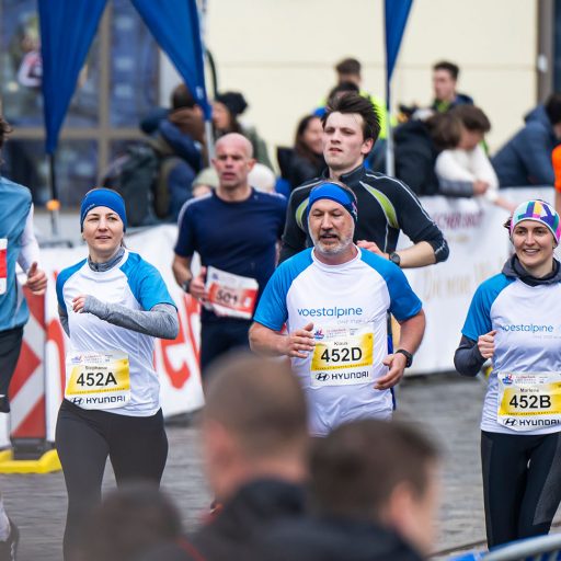 zwei voestalpine Mitarbeiterinnen und ein Kollege beim Zieleinlauf am Linzmarathon