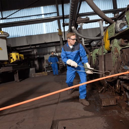 Mitarbeiter arbeiten mit glühendem Stahl in der Walzstraße bei voestalpine Böhler