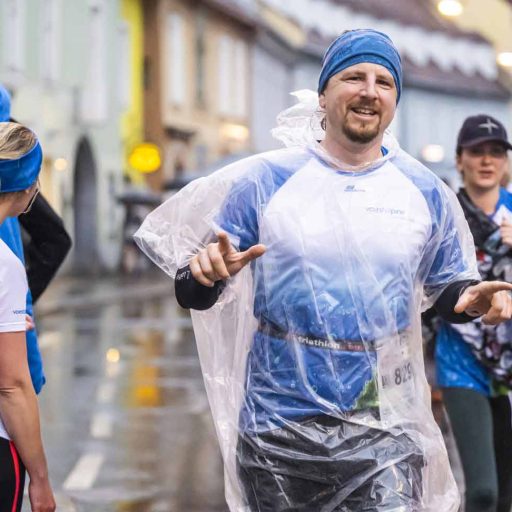 voestalpine Läufer amBruckner-Businesslauf nach dem Lauf mit regenponcho