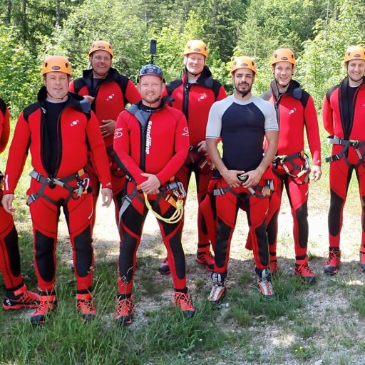 Gruppenfoto der Mitarbeiter in Neopren Anzügen beim Canyoning