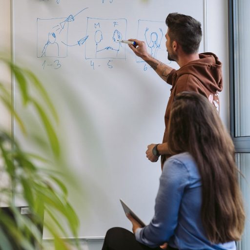 Michael zeichnet am Whiteboard ein Storyboard für ein Fotoshooting zu einer Kampagne