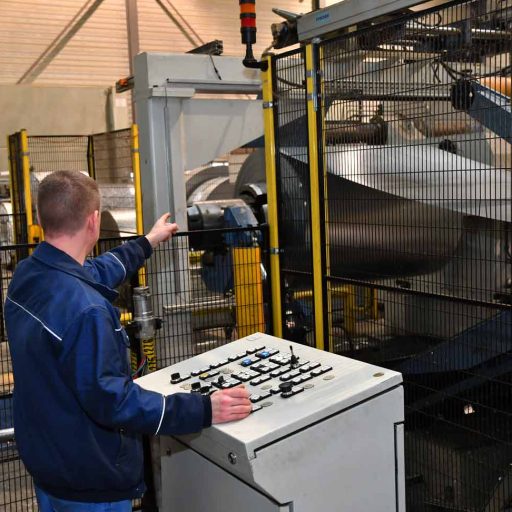 Christian in the production hall, a large steel roll in the background