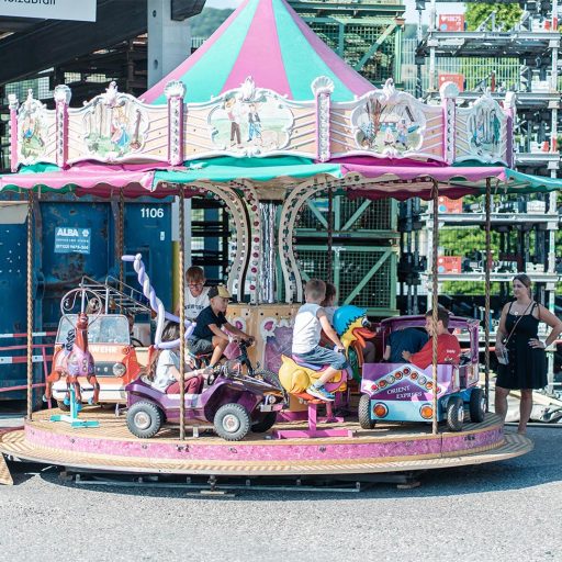 Kinder fahren mit dem Autokarusell