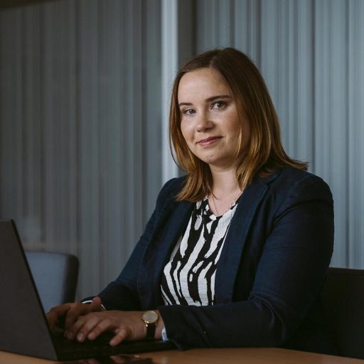 Portrait photo of Service Manager Katharina while working on her notebook